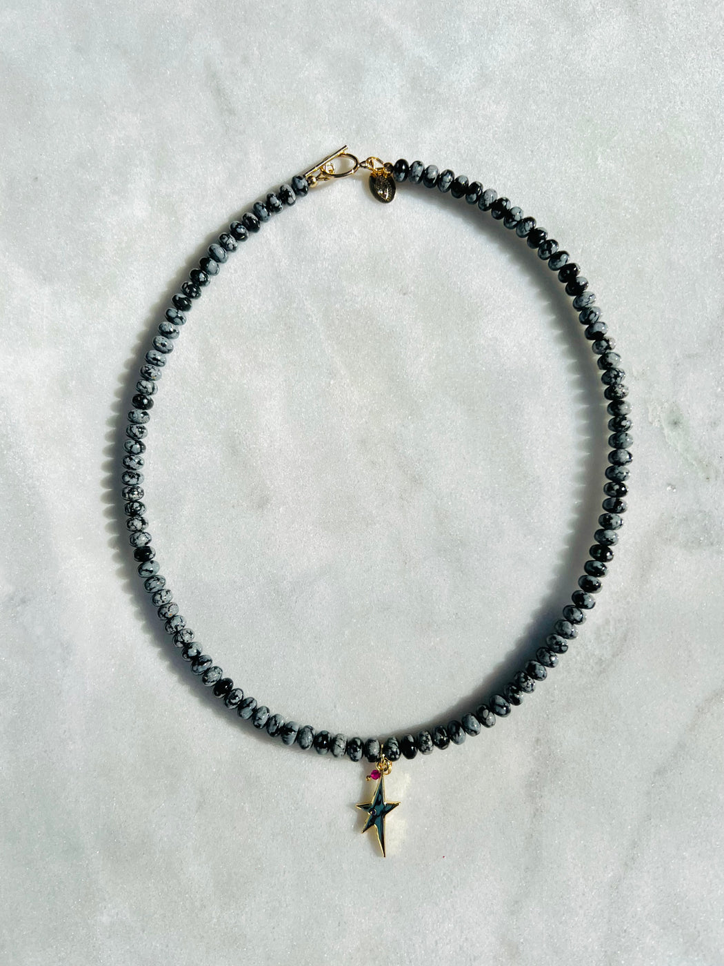18" Obsidian strung on coated gold wire, with Gold Vermeil clasp. Accented with punk star charm and ruby   