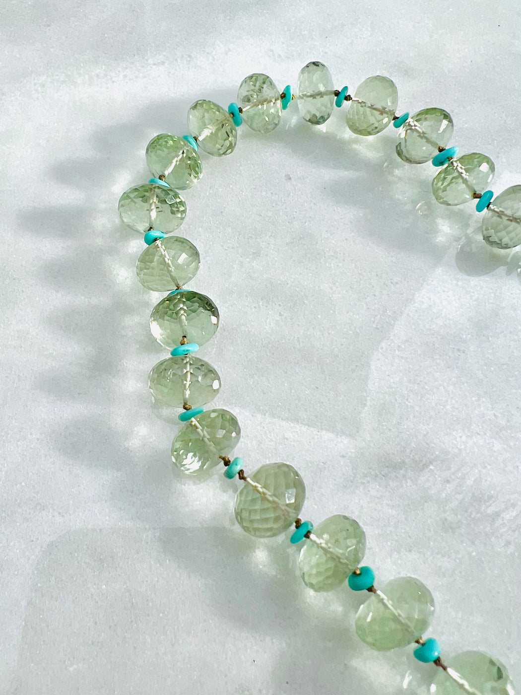 Faceted Green Amethyst spaced with turquoise on hand knotted silk chord with gold fill clasp. 19"