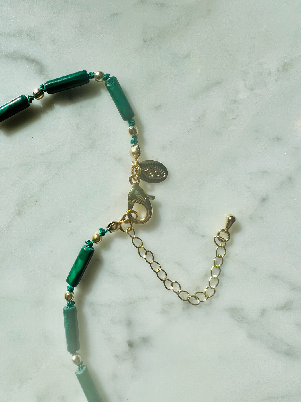 Rise from the ashes. Face your shadows & alchemize the darkness into light with the help of Malachite - the stone of Transformation. Hand knotted on silk chord, Roman gold coin with gold fill beads to light the way ~ 22" necklace designed by Carrie Marill