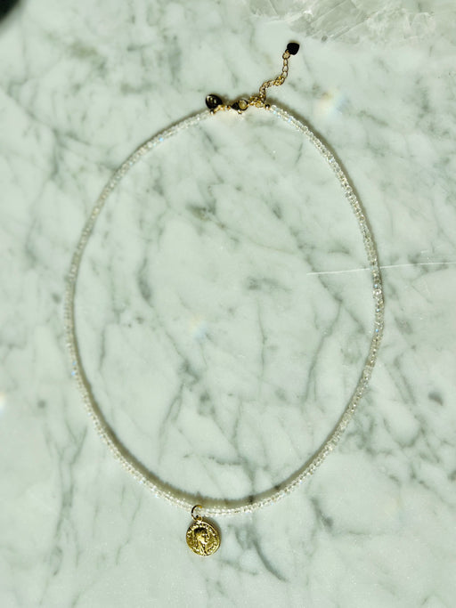Moonstones metallic white, ethereal energy connects us to the Goddess, Mother Nature & that grounded depth we're all searching for...  Faceted Moonstone, strung on gold coated wire, gold fill clasp & Roman gold coin. necklace designed by Carrie Marill
