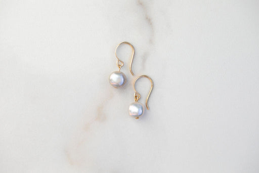Small Pearl Coin Earrings with 14k gold details.  These minimalist beauties are a go to staple - they capture a glint of light perfectly around your face. There's just something about a simple pearl earring, like a beautifully constructed sentence - it just works.